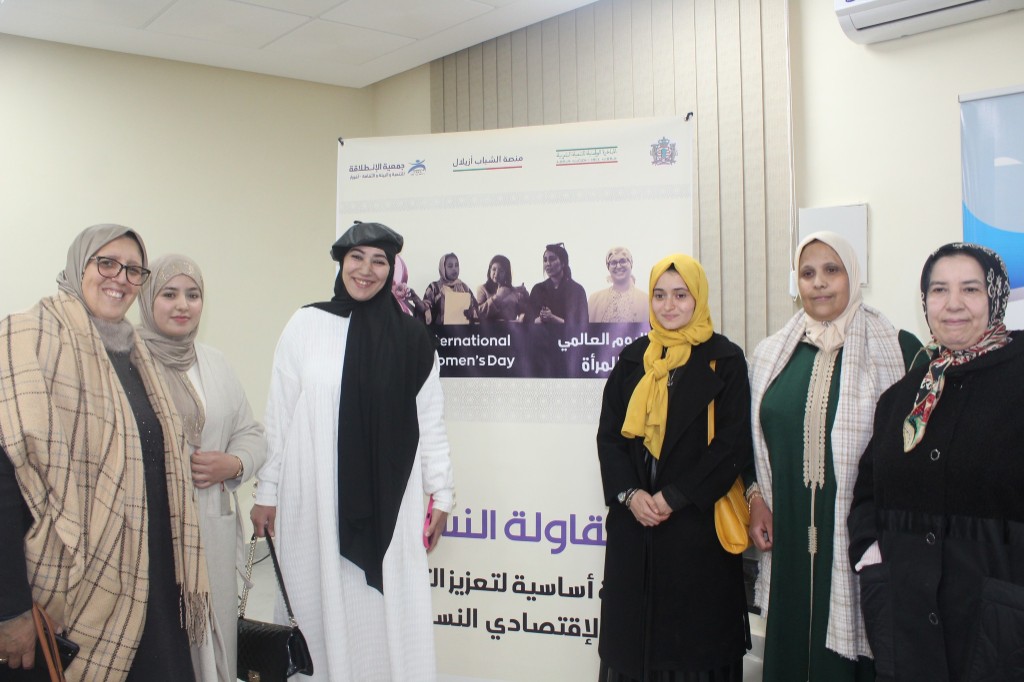 Participants in front of International Women's Day banner — women's entrepreneurship and economic empowerment